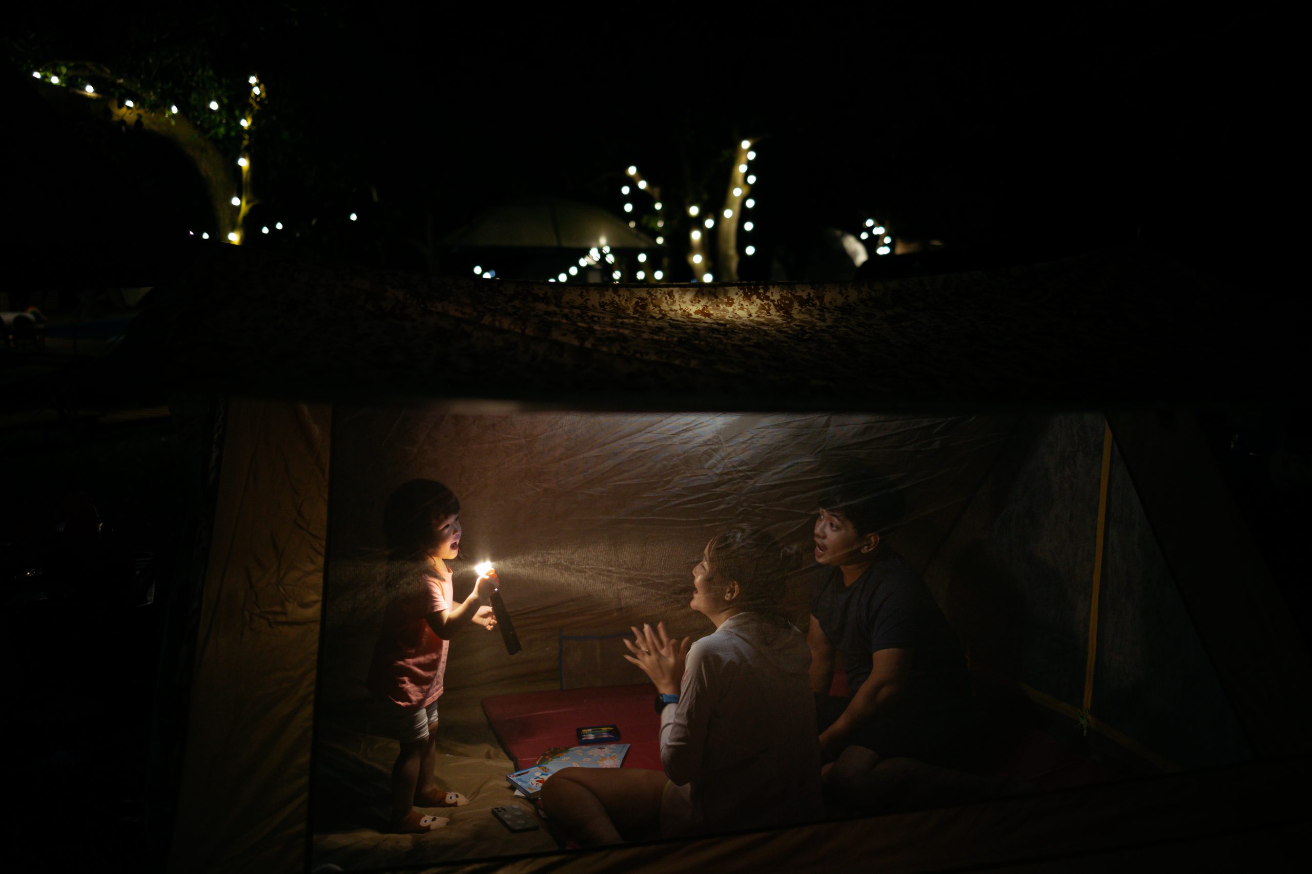 Chụp ảnh gia đình 3 người đi cắm trại vào ban đêm.